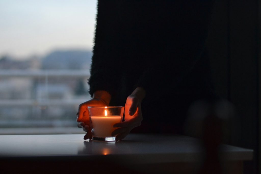 person hands near lighted candle